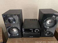 Full view of Philips audio system including central CD player unit and two speakers.