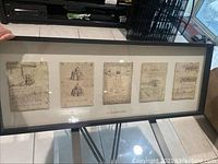 Wide shot of the full framed piece showing the layout of five parchment style prints in one frame.