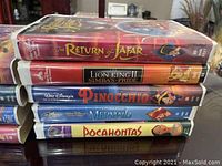 Photo showing Disney VHS tapes of The Return of Jafar, Lion King II: Simba's Pride, Pinocchio, The Little Mermaid, and Pocahontas stacked showing titles.