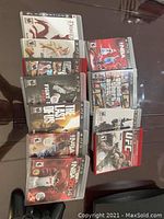 Top view of 11 PlayStation 3 game cases laid out on table showing titles and covers.