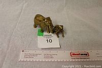 Both brass figurines together with a ruler for scale, elephant approximately 3.5 x 3 inches, frog approximately 2 x 2 inches.