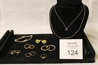 All jewelry pieces laid out on black display tray.