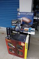 Overview of all items arranged on platform, including lap desk box, Antec chassis box, PSU box, HP box, cooler box, mouse and cables