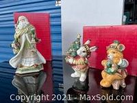 Two woodland animal figurines (mouse and rabbit) on a Fitz & Floyd red box, featuring holiday attire and Christmas decorations.