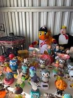 Assorted Halloween figurines displayed together, featuring owls, pumpkins, ghosts, and cartoon-like characters in various colors.