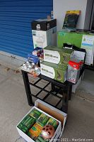 Photo showing various boxed bulbs, mosquito coils, and a small black metal stand