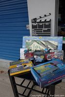 Photo showing all items in the lot including microscope set, electrical lab kit, Star Wars and Twilight Zone collectibles, and a film production clapboard