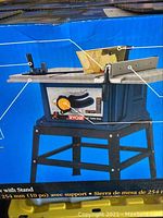 Box front showing Ryobi branding and illustration of table saw with stand
