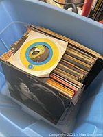 Bin of vinyl records showing various LP and single sleeves