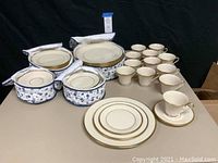 Overall display showing stacks of plates, coffee cups, saucers, and storage cases