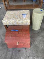 Photo showing the full lot arranged: ottoman, ceramic side table, and wooden chest