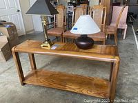Sofa table with two lamps on top, showing overall look and style.