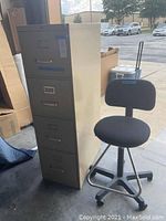 Front and side view of the beige metal 4-drawer file cabinet and black office chair with casters and adjustable seat.