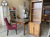 Desk, chair and cabinet arranged side by side in warehouse setting.