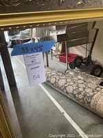 Full view of gold framed mirror showing painted wood frame with decorative scrolling and beveled glass surface. Measurement label 33x45 inches is visible.