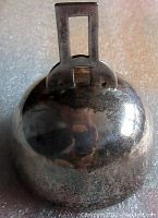 Top view of the bell showing the hinged rectangular handle and the tarnished round silver body