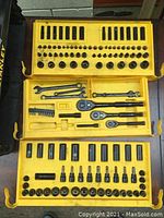 Open yellow trays of the toolbox showing neatly arranged socket wrench set, ratchets, combination wrenches, and screwdriver bits