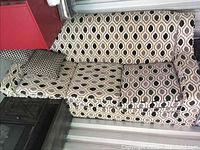 Side view of the three-seat sofa showcasing the patterned upholstery and one armrest.