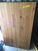 Rectangular wooden table top with natural wood finish, photo taken to show table condition and surface pattern.