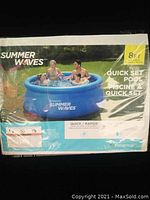 Box packaging of the Summer Waves inflatable quick set pool showing family using the pool outdoors, with details on size and brand visible.
