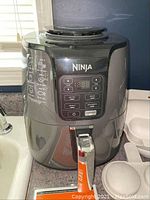 Ninja Air Fryer model AF100 S5 showing front control panel and closed basket
