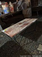 Full view of the rectangular coffee table showing the metal legs and wood top surface with wear.