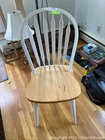 Photo of a single white wooden kitchen chair with spindle back and light wood seat showing front view, scratches visible on seat.