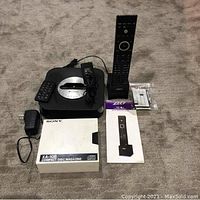 RTI T1-B universal remote, Sony XA-10B CD magazine case, power adapters, manuals, and accessories.