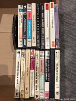 Photo of 20 assorted reel to reel tapes stacked upright showing various spine labels with album titles and artists.