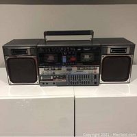 Front view of Sharp GF-800Z boombox showing both speakers attached, cassette decks, and controls.