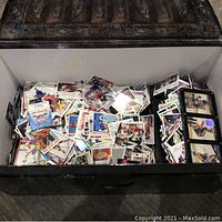Large trunk opened, showing hundreds of loose old hockey and other sports cards inside.