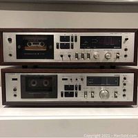 Two stereo cassette decks stacked, the top is Luxman K-117 and bottom Luxman K-8, showing front panels and wood sides.