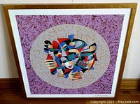 Angled photo of the framed seriolithograph showing the artwork and signature at bottom right.