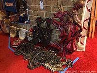 Both bullfighter and bull wall sconces displayed together on floor against a brick wall with several other decorative pieces in the background.