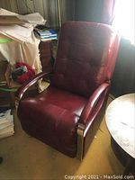 Side view of burgundy leather recliner chair with chrome arms in room