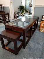 Full view of coffee table and two side tables showing wood frame and glass inset of coffee table.