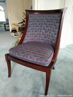 Front view of dark wood chair with patterned blue and purple upholstery, showing seat cushion and curved back.