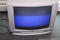 Full view of JVC 27-inch CRT TV turned on showing blue screen half on.