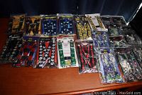 Wide shot of 15 packaged suspenders on wooden table all new and unopened.