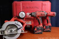 Full set of Milwaukee power tools on table with carrying case behind