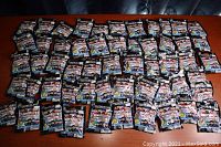 Overview of approximately 72 Teeny Mates NHL blind bags laid out on a table, all new and sealed.