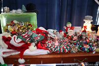 Overall view of Christmas holiday decorations including hats, light strings, ornaments, and festive figurines on a table.
