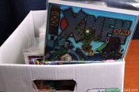 White comic short box filled with assorted bagged comics showing a visible X-Men Alpha comic at front.