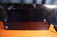 Front view of broken Sharp LCD TV screen showing cracks and liquid crystal damage.