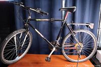 Full side profile of the black B.R.C Trailblazer mountain bike showing frame, seat, handlebars, and luggage rack