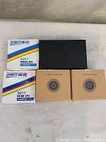 Two boxed Sports HD DV SQ11 Mini DV cameras, two boxed Full HD webcams, and black box containing wireless network camera manual.