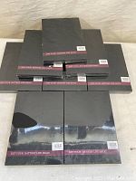 Eight sealed boxes of iPhone 8 Plus battery replacement kits stacked in a pyramid shape. Packaging is black with a purple band and barcode label visible.