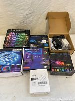 Full view of all 7 LED strip light boxes and one open box showing power adapters and wiring.