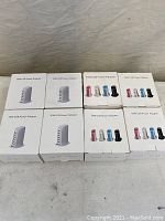 Eight 30W USB power adapters in original retail boxes shown on flat surface. Four boxes are white adapters, four boxes show color options with pink, white, blue, black.
