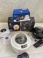View of six assorted room light projectors, some boxed, showing different models including moon light and star projector with various designs and colors.